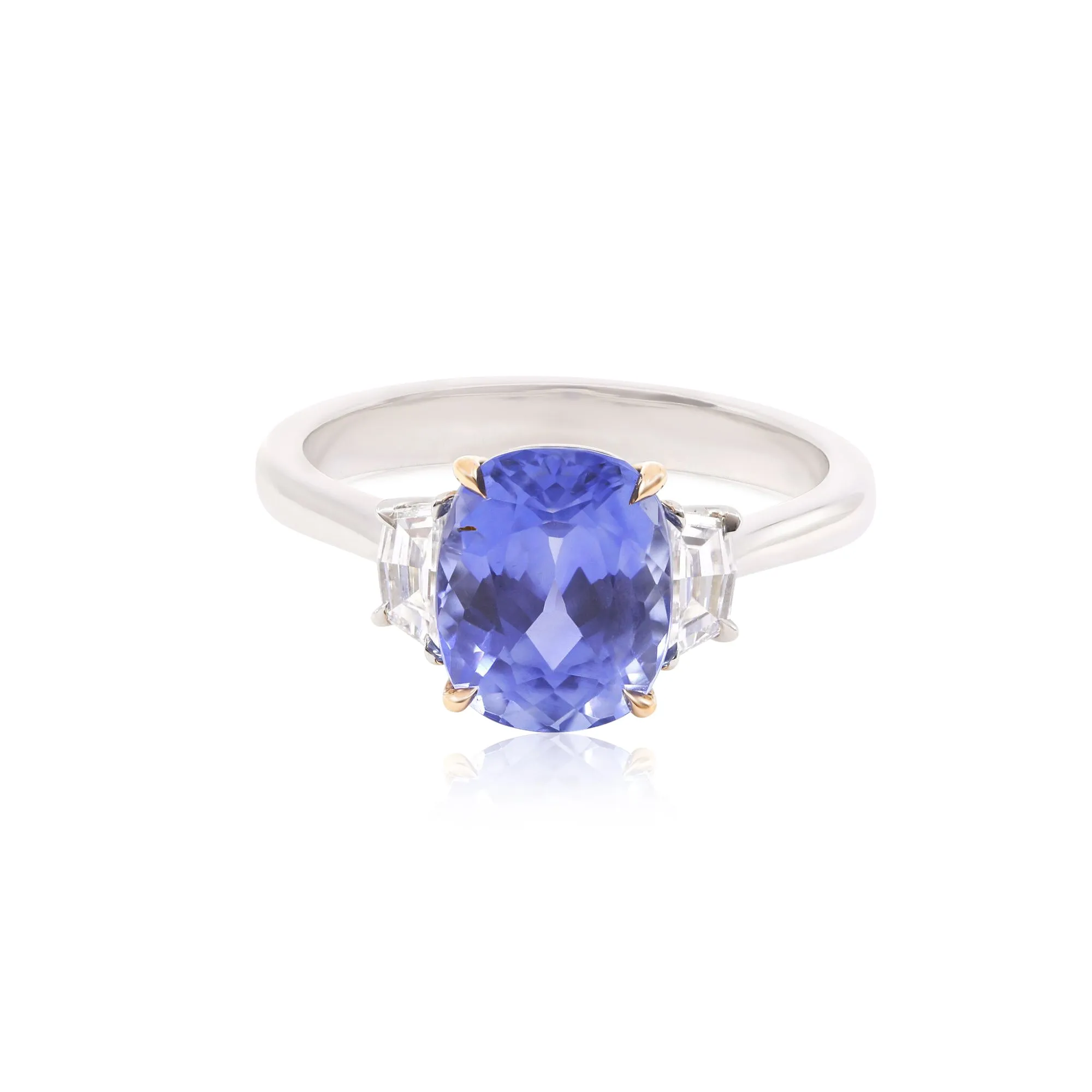 PLATINUM AND 18K ROSE GOLD THREE-STONE RING WITH A CUSHION BLUE SAPPHIRE AND CADILLAC STEP-CUT SIDE DIAMONDS 0.43CTW